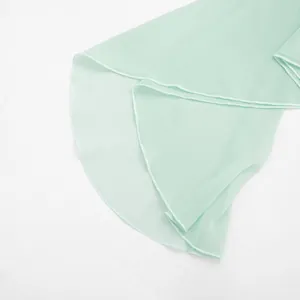 Close-up view of the delicate mint green mesh ruffled hemline on a summer mini dress