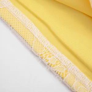 Close-up detail of white floral lace edging and yellow ribbed knit fabric texture