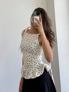 Detalle del top de lunares blanco con dobladillo de volantes y tirantes para anudar