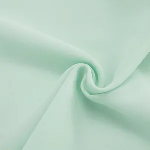 Macro view of soft mint green mesh fabric showing its fine texture and elegant drape