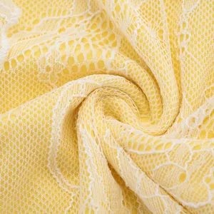Macro close-up of delicate yellow floral lace fabric showing intricate hollow-out texture