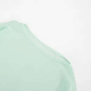 Detail view of mint green mesh dress showing fine stitching and semi-transparent fabric.