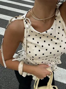 Detalle de top de lunares blancos con hombros anudados y volantes con accesorios