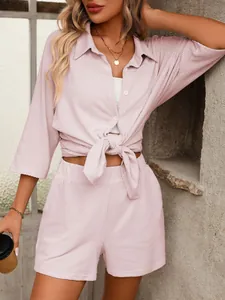 Detail shot of pink striped short sleeve shirt and high waist shorts casual two-piece set.