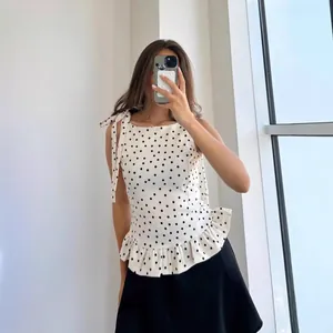 Elegante top blanco sin mangas con lunares, dobladillo con volantes y lazos verano
