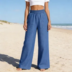Weite Denim-Hose mit hohem elastischem Bund in einer sonnigen Strandkulisse