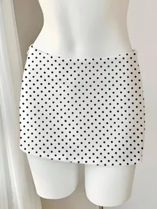 Nahaufnahme eines weißen Bodycon-Minirocks mit klassischem schwarzem Punktmuster