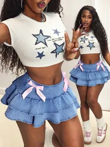 Detail view of blue denim tiered mini skirt with pink bows and star print crop top