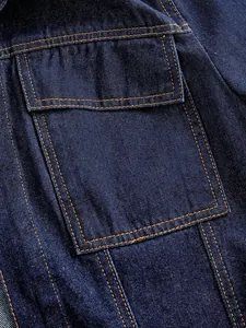 Detailansicht der Pattentasche und Nähte an einer dunkelblauen Jeansjacke