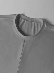 Primer plano detallado del cuello redondo y costura frontal en top gris