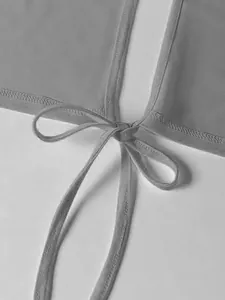 Primer plano detallado que muestra el elegante nudo cruzado en el bajo de un top corto