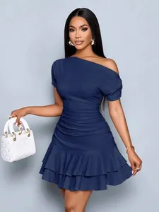 Detail view of elegant navy blue off-shoulder dress with textured fabric and ruffled hem