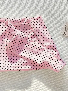 Detailaufnahme eines rosa Minirocks mit Polka-Dot-Print zeigt Stofftextur und Doppelsaum.
