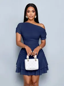 Detailed view of an elegant blue one-shoulder dress with ruffled hem and pleated texture