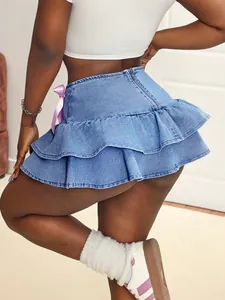 Detailed close-up showing the ruffles and purple ribbon bow on this blue denim mini skirt