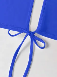 Detalle de la parte superior azul real con nudo decorativo y textura de la tela