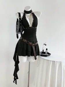 Vista detallada de un sexy vestido corto negro con cuello halter y tachuelas.