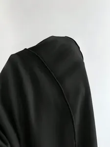 Primer plano de la costura fina y la textura de la tela de un vestido halter negro de primera calidad