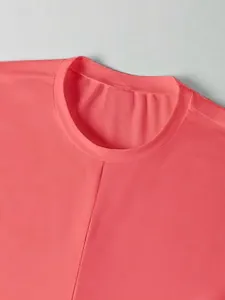 Primer plano del cuello redondo de un top corto rosa coral de corte ajustado para verano