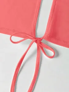 Primer plano detallado del elegante nudo frontal rosa coral en un top corto de verano chic