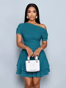 Close-up detail of a teal one-shoulder ruffled mini dress with elegant textured fabric