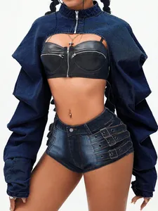 Detail of fashion cropped denim jacket paired with buckled shorts on studio model