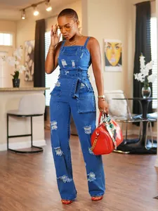Detail view of fashionable distressed denim jumpsuit with tie-belt and wide leg cut.