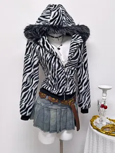 Detailed view of a zebra print faux fur hooded jacket styled with a denim mini skirt
