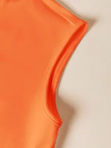 Detalle de cerca de la costura de la manga en un top de verano de color naranja vibrante