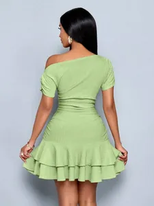 Rear view of light green off-shoulder dress with elegant ruffled hem details.