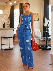 Stylish distressed blue denim jumpsuit for women presented in a modern indoor setting.