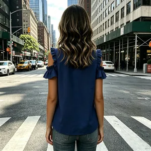 Detail back view of a navy blue cold shoulder top with ruffle sleeves on a street