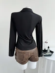 Back view of a sleek black long-sleeve shirt paired with stylish brown shorts ensemble.