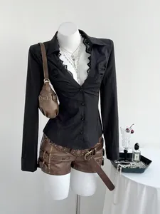 Detail view of black V-neck lace-trimmed long-sleeved shirt styled with leather shorts
