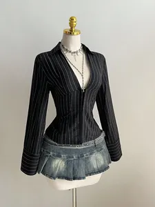 Dettaglio di camicia a righe con scollo a V e minigonna di jeans a pieghe.