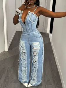 Detail view of light blue distressed denim jumpsuit with ripped legs and studded bodice