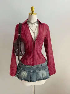 Dettaglio di una camicia a maniche lunghe a righe rosso e oro con scollo a V