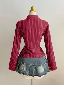 Vista posteriore di un'elegante camicia a righe bordeaux a maniche lunghe su un manichino