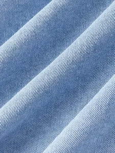 Dettaglio ravvicinato della trama del tessuto denim azzurro per giacca da donna