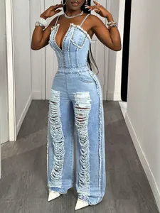 Sexy light blue distressed denim jumpsuit with metallic studs and raw hem details