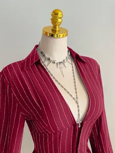 Dettaglio di una camicia rossa a righe a maniche lunghe con scollo a V e bottoni