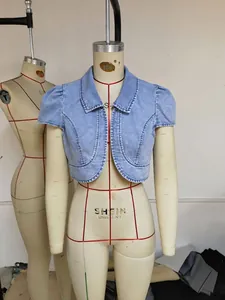 Primo piano di una giacca di jeans corta a maniche corte azzurro su un manichino