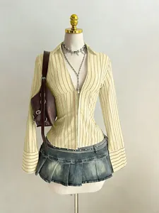 Dettaglio di una camicia a righe slim fit da donna con scollo a V sopra un manichino.