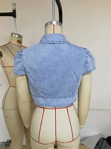 Vista posteriore dettagliata di un coprispalle in denim azzurro con maniche a sbuffo su manichino