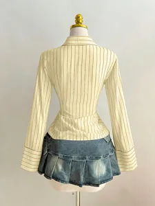 Vista posteriore di una camicia a righe slim fit a maniche lunghe con minigonna in denim
