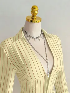 Dettaglio di una camicia slim fit a righe gialle con scollo a V su un manichino sartoriale
