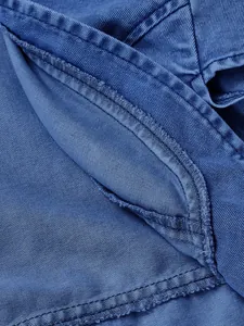 Vista macro dettagliata del tessuto denim blu che mostra trama e cuciture di pregio