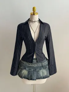Primo piano di una sexy camicia a maniche lunghe a righe e mini gonna di jeans a pieghe