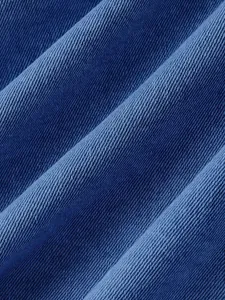 Primo piano che mostra la trama saia dettagliata e la consistenza del tessuto denim blu