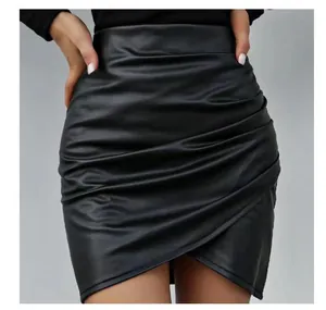 Close-up of black PU leather mini skirt with irregular hem and ruched waist detail